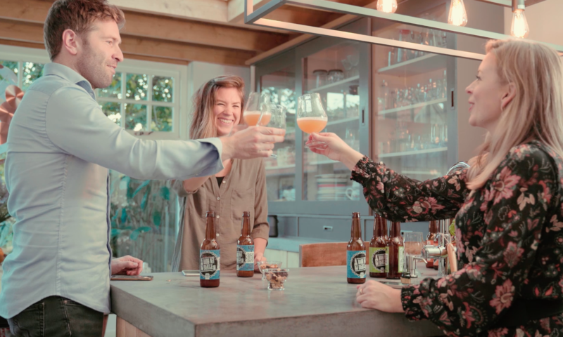 Man en twee vrouwen proosten met bier bij raad het biertje